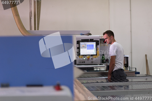 Image of worker in a factory of wooden furniture