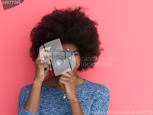 Image of young black girl taking photo on a retro camera