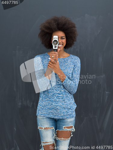 Image of african american woman using a retro video camera