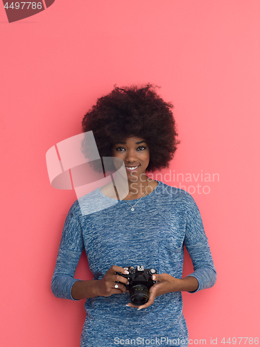 Image of young black girl taking photo on a retro camera