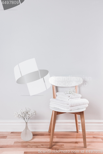 Image of White towels on a chair in a bright interior