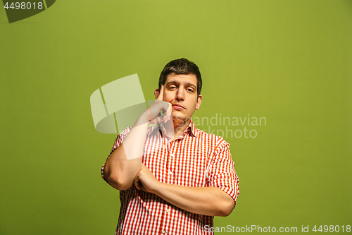 Image of Beautiful bored man isolated on green background