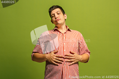 Image of The happy businessman standing and smiling against green background.