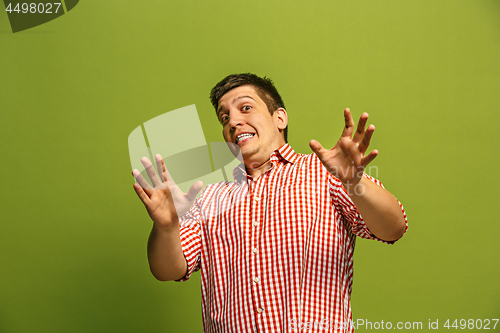 Image of Let me think. Doubtful pensive man with thoughtful expression making choice against green background