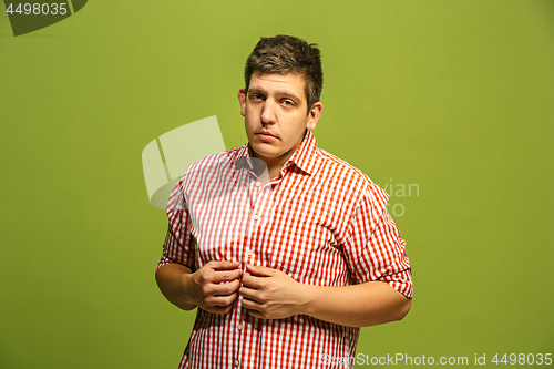 Image of Beautiful man looking suprised and bewildered isolated on green