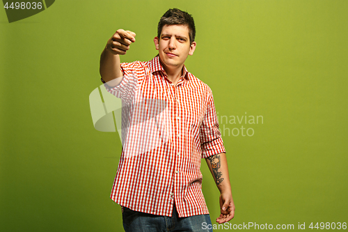 Image of The happy business man point you and want you, half length closeup portrait on green background.