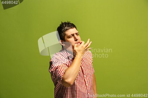 Image of Isolated on green young casual man shouting at studio