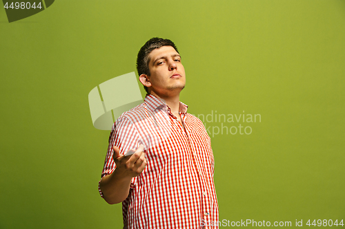 Image of The happy business man point you and want you, half length closeup portrait on green background.