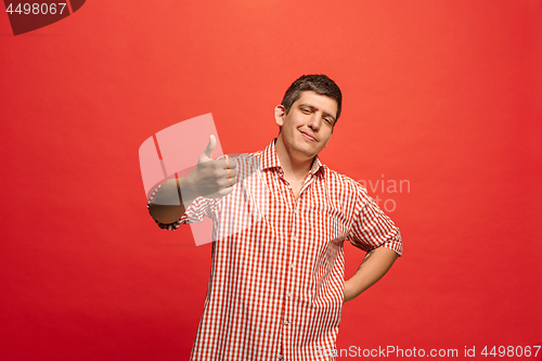 Image of The happy businessman standing and smiling against red background.