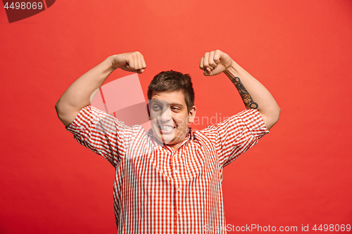 Image of Handsome young man showing biceps expressing strength and gym concept,