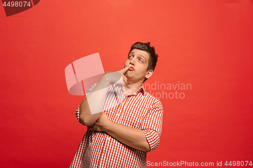 Image of Beautiful bored man isolated on red background