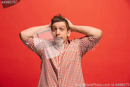 Image of Man having headache. Isolated over red background.