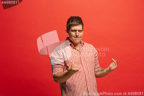 Image of Beautiful male half-length portrait isolated on red studio backgroud. The young emotional surprised man