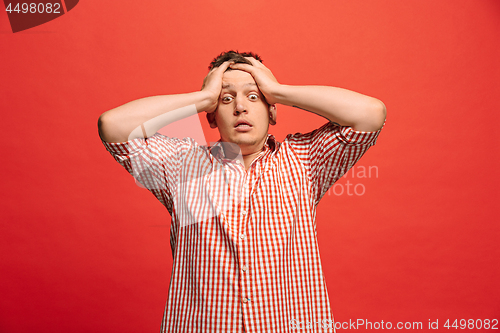 Image of Man having headache. Isolated over red background.