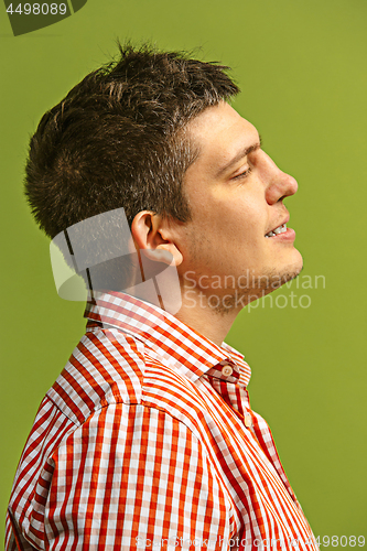 Image of The happy business man standing and smiling against green background.