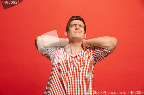 Image of Man having headache. Isolated over red background.