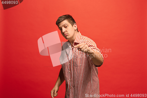 Image of Beautiful male half-length portrait isolated on red studio backgroud. The young emotional surprised man