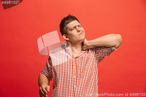 Image of Man having headache. Isolated over red background.