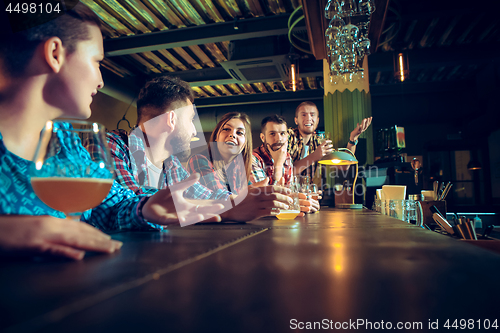 Image of Sport, people, leisure, friendship and entertainment concept - happy football fans or male friends drinking beer and celebrating victory at bar or pub