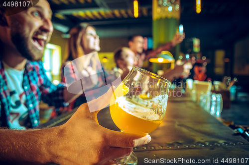 Image of Sport, people, leisure, friendship and entertainment concept - happy football fans or male friends drinking beer and celebrating victory at bar or pub