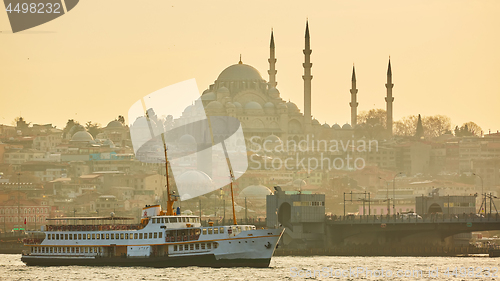 Image of Tourist boat sails on the Golden Horn in Istanbul at sunset, Turkey.