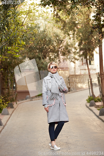 Image of Young blond woman with sunglases on the street