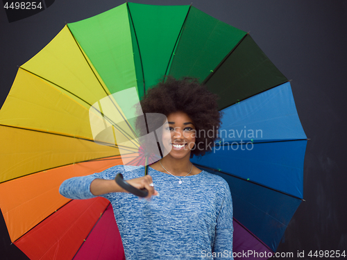 Image of african american woman holding a colorful umbrella