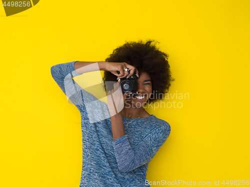 Image of young african american girl taking photo on a retro camera