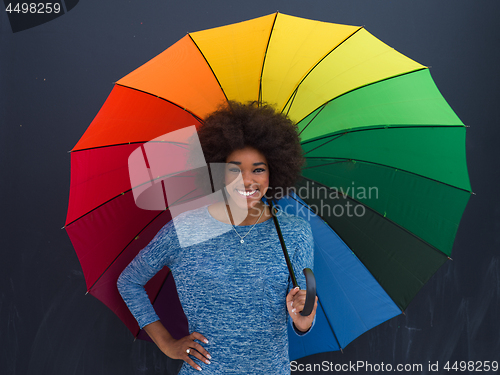 Image of african american woman holding a colorful umbrella