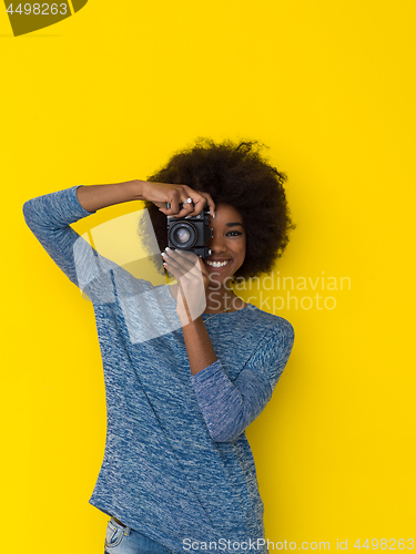 Image of young african american girl taking photo on a retro camera