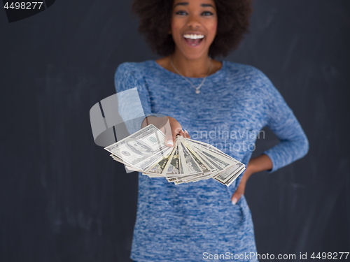 Image of black woman holding money on gray background