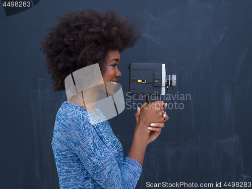 Image of african american woman using a retro video camera