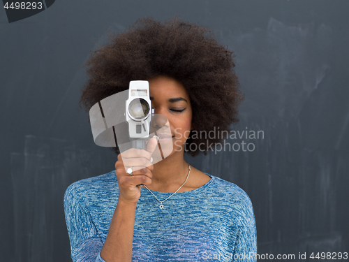 Image of african american woman using a retro video camera