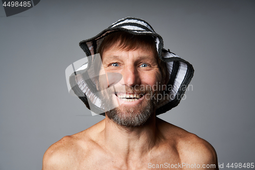 Image of Funny portrait of mature man topless wearing summer hat