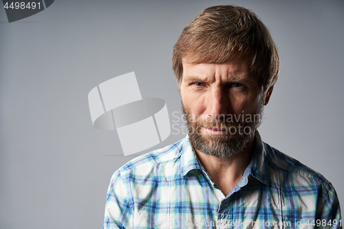 Image of Studio portrait of smiling mature man in checkered shirt