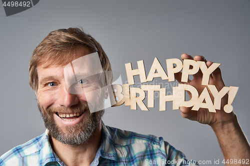 Image of Studio portrait of smiling mature man in checkered shirt