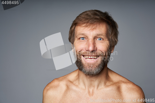 Image of mature man shirtless standing smiling at camera