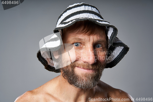 Image of Funny portrait of mature man topless wearing summer hat