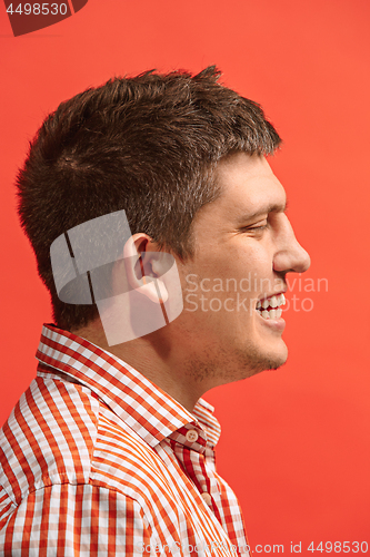 Image of The happy business man standing and smiling against red background.