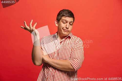 Image of Beautiful man looking suprised and bewildered isolated on red