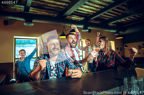 Image of Sport, people, leisure, friendship and entertainment concept - happy football fans or male friends drinking beer and celebrating victory at bar or pub