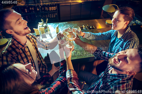 Image of Sport, people, leisure, friendship and entertainment concept - happy football fans or male friends drinking beer and celebrating victory at bar or pub