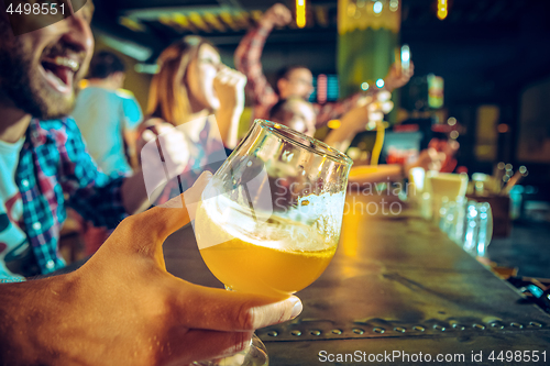 Image of Sport, people, leisure, friendship and entertainment concept - happy football fans or male friends drinking beer and celebrating victory at bar or pub