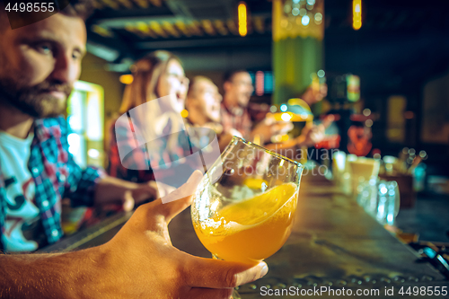 Image of Sport, people, leisure, friendship and entertainment concept - happy football fans or male friends drinking beer and celebrating victory at bar or pub