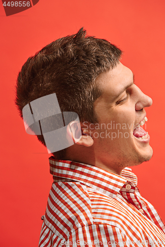 Image of The happy business man standing and smiling against red background.