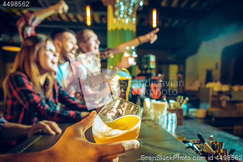 Image of Sport, people, leisure, friendship and entertainment concept - happy football fans or male friends drinking beer and celebrating victory at bar or pub