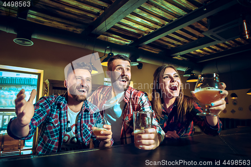 Image of Sport, people, leisure, friendship and entertainment concept - happy football fans or male friends drinking beer and celebrating victory at bar or pub