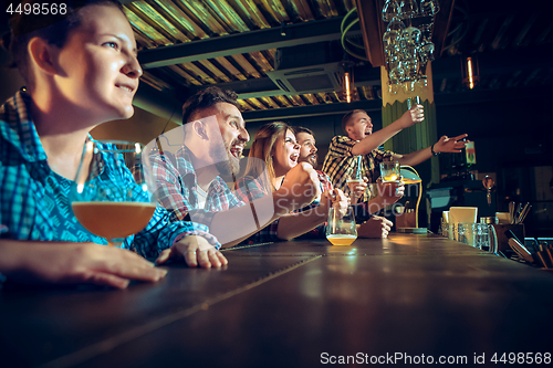 Image of Sport, people, leisure, friendship and entertainment concept - happy football fans or male friends drinking beer and celebrating victory at bar or pub