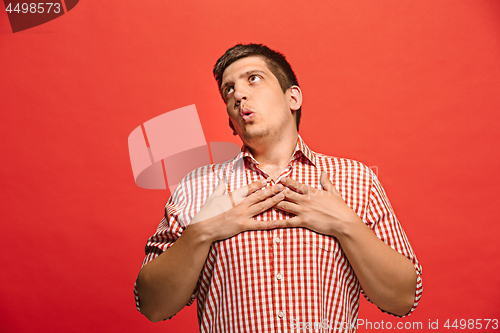 Image of The happy business man standing and smiling against red background.