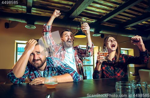 Image of Sport, people, leisure, friendship and entertainment concept - happy football fans or male friends drinking beer and celebrating victory at bar or pub